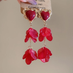 Detail of red heart resin earrings with golden frame and layered translucent petals
