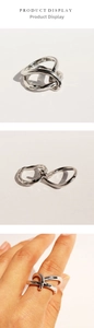 Detail of silver double-layered knotted ring with creative minimalist entwined metal design
