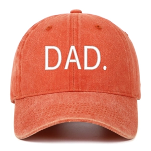 Close-up of white DAD. embroidery on a vintage washed orange cotton baseball cap