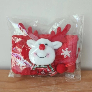 Détail de sac de Noël avec un renne en peluche 3D sur tissu tricoté rouge