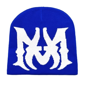 Detailed close-up of blue knitted beanie featuring white Gothic MM jacquard lettering