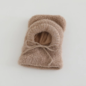 Close-up of brown plush balaclava hood with cute ears and a bow tie for kids winter wear