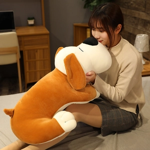 Detailed view of large plush sleeping dog toy in brown and white being held for size