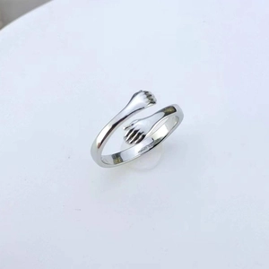 Detail of silver hugging hands ring showing the polished finish and adjustable band