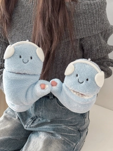 Close-up of soft light blue plush gloves featuring cute embroidered smiley faces and ears
