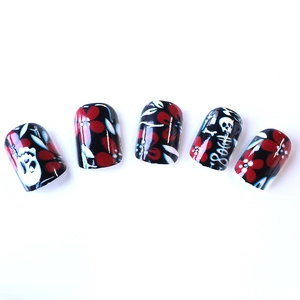 Short square gothic press-on nails featuring dark skull and red flower patterns
