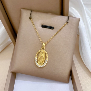 Close-up of golden oval medallion necklace with crystals in a beige jewelry gift box