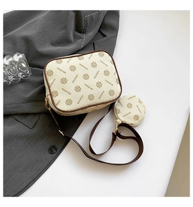 Detail of off-white camera bag set with brown pattern and golden metal hardware
