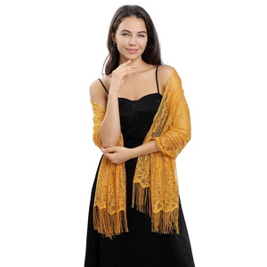 Close-up of vibrant yellow lace shawl with floral hollow pattern and long fringe trim