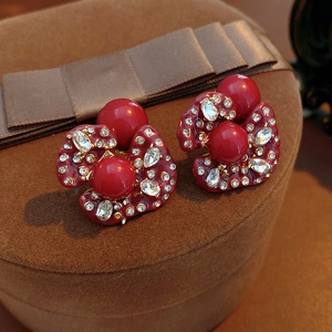 Close-up of vintage burgundy floral earrings with sparkling rhinestones on jewelry box