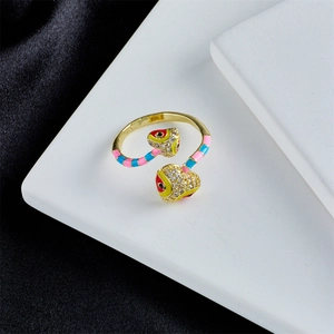 Close-up of golden double-headed snake ring with colorful enamel and zircon stones