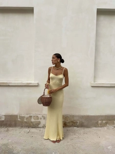Detail of light yellow knit long dress showing ribbed texture and minimalist summer style