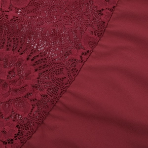 Detailed macro view of the delicate lace stitching and burgundy fabric of the dress