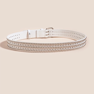 Détail d'une ceinture punk en cuir blanc avec trois rangées de clous étoiles dorées