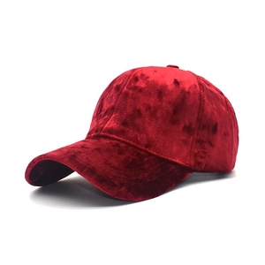 Detailed close-up of a burgundy velvet baseball cap with a classic curved brim design