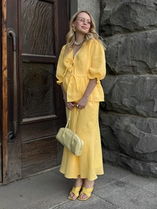 Detail of bright yellow V-neck crop top with ruffle sleeves and matching long skirt set