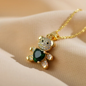 Golden teddy bear necklace with green heart gemstone and white zircon pavé setting