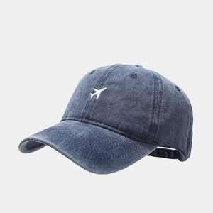 Detailed side view of washed navy cotton baseball cap with white airplane embroidery