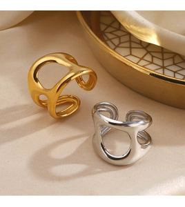 Detailed view of hollow geometric gold and silver rings on silk with porcelain