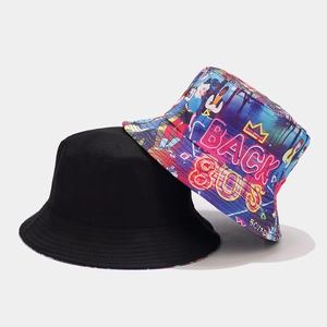 Detailed view of reversible bucket hats in plain black and retro 80s graffiti patterns