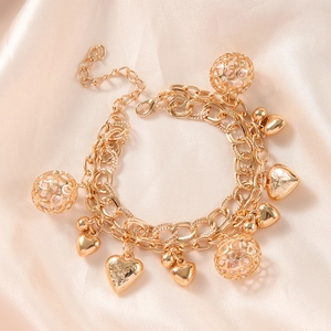Bracciale multistrato dorato con ciondoli a cuore e sfere traforate su seta beige