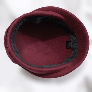 Detail of wool beret interior showing 100% wool label and 57cm size measurement