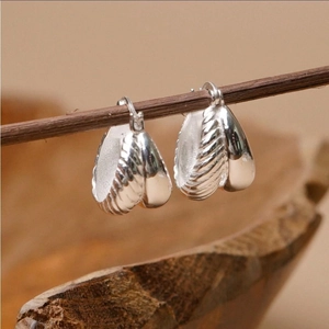 925 sterling silver double curved hoop earrings with textured finish on wood branch
