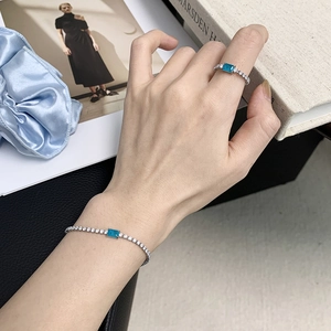Blue rectangular crystal jewelry set with silver ring and bracelet on hand