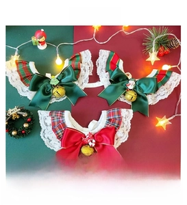 Macro detail of Christmas plaid pet bibs with lace trim, bells, and festive resin charms