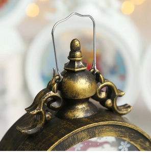 Detail showing vintage bronze candle lantern with metal hanging hook and ornate floral carvings