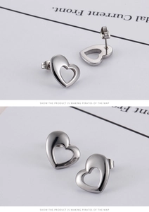 Détails macro des boucles d'oreilles cœur évidé en acier inoxydable poli avec fermoirs