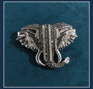 Detailed view of an elephant brooch with silver plating and sparkling black crystals