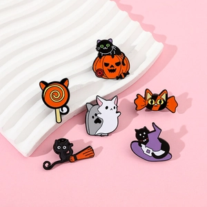 Close-up of Halloween cat enamel pins featuring pumpkin, witch hat and ghost designs