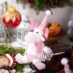 Close-up of pink plush Christmas reindeer doll with sequins and festive knit hat