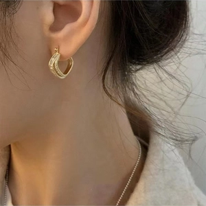 Macro view of gold-plated square hoop earrings with sparkling cubic zirconia inlay