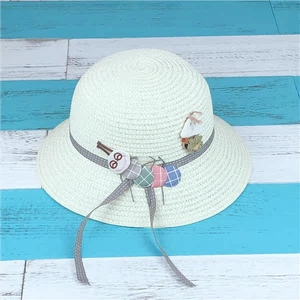 Detailed top view of kids straw sun hat with cute caterpillar doll and ribbon
