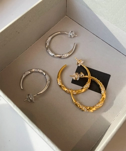 Detail showing twisted gold and silver hoop earrings with micro-inlaid cubic zirconia