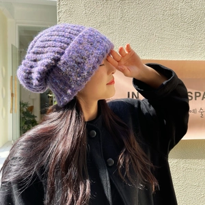 Close-up of thick purple knit beanie with chunky yarn texture and cozy rolled edge