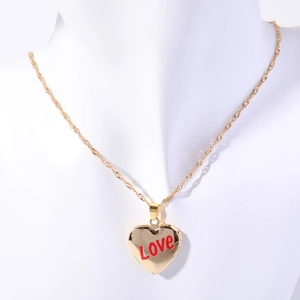 Macro shot of gold-plated heart locket with red Love text on a white neck model