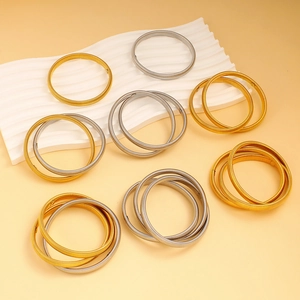 Minimalist gold and silver spring coil bracelets on a stylish display tray