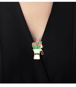 Close-up of white moka pot enamel pin with pink tulips worn on black clothing