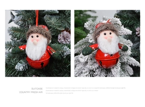 Detail of red metal bell and plush Santa Claus ornament on a Christmas tree branch