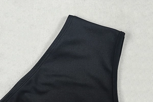 Detail of double-needle stitching on black sleeveless dress neckline with subtle sheen