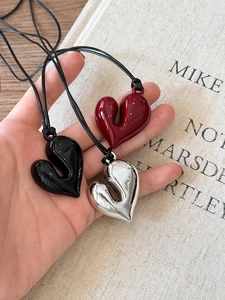 Dettaglio dei ciondoli a cuore 3D in nero, rosso e argento con cordino nero regolabile