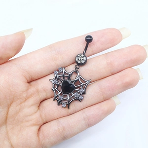 Macro view of black spider web heart navel ring with crystals held by hand