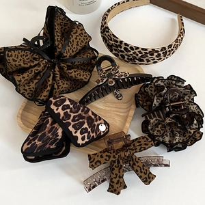 Detail shot of leopard print hair accessory set with fabric scrunchie and claw clips
