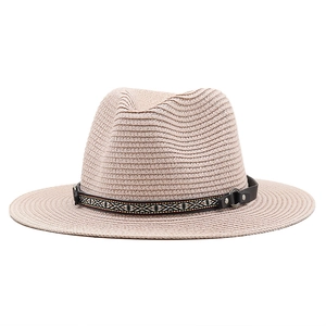 Détail d'un chapeau de paille avec bande en cuir ethnique et anneau métallique décoratif