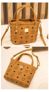 Detailansicht der braunen Bucket Bag mit schwarzem Monogramm und goldfarbenen Nieten