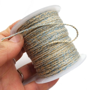 Close-up of multicolor braided cotton cord on white spool for DIY jewelry making