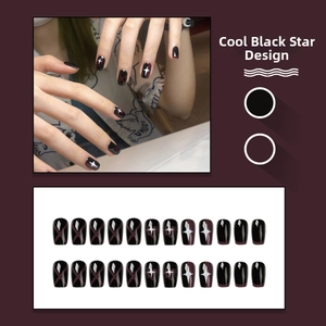 Detailed view of black press-on nails with white stars and dark red cross patterns